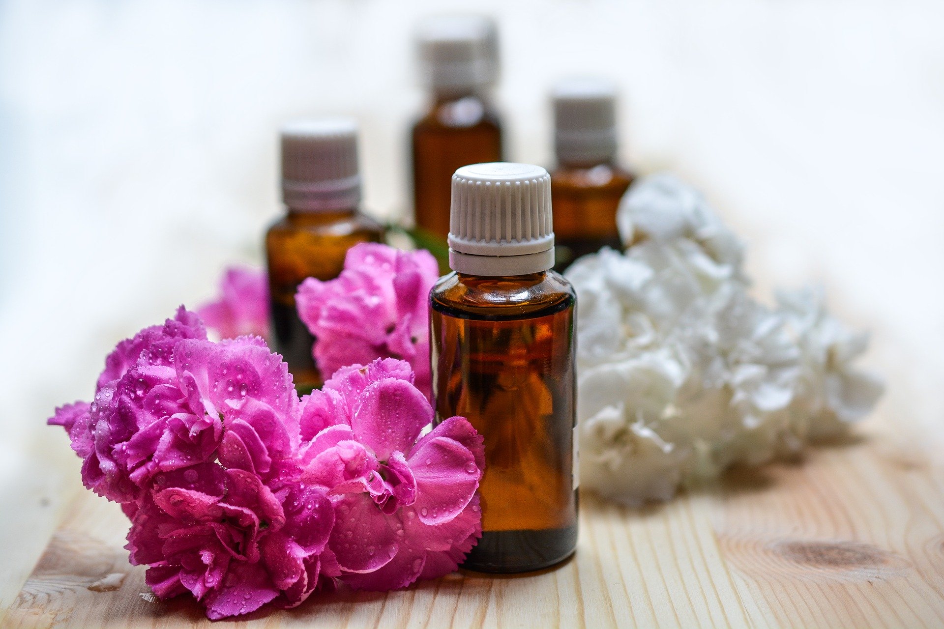 Bottles of essential oils with flowers.